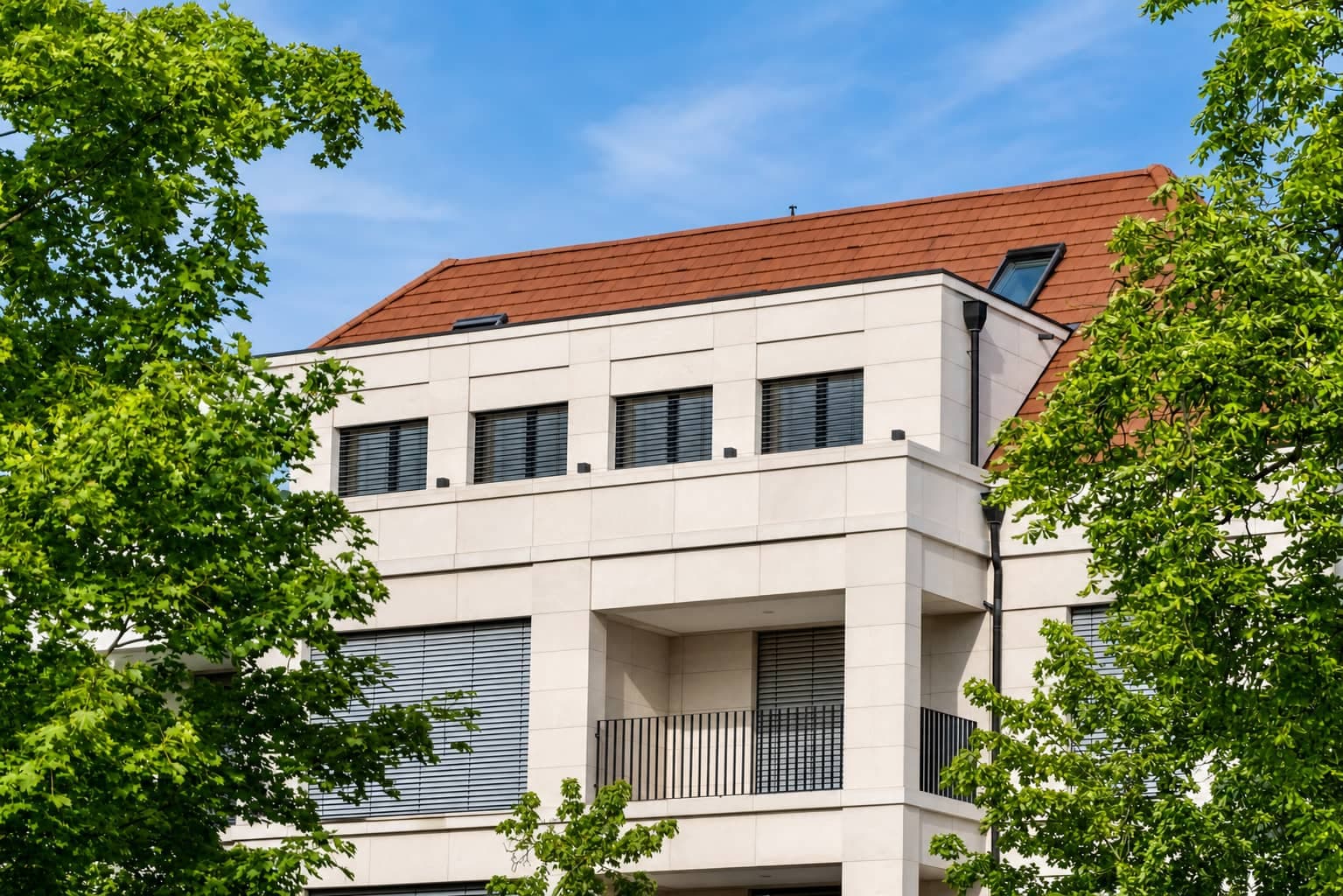Penthouse-Neubau mit Natursteinfassade zwischen Bäumen im Zooviertel, Hannover